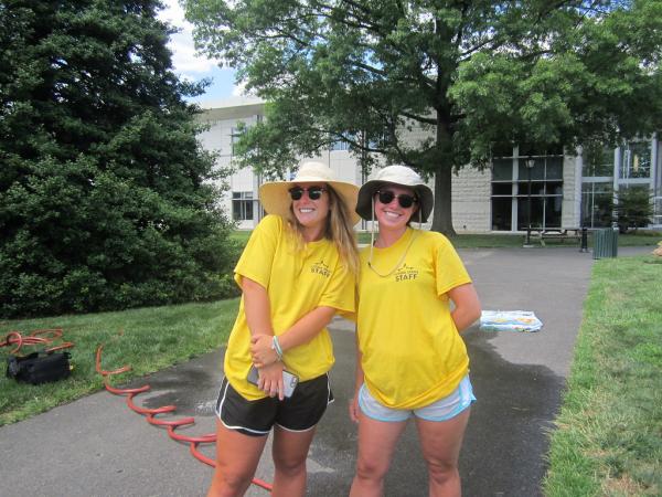 two young female camp counselors posing with sunglasses and hats on - join our team for the summer!