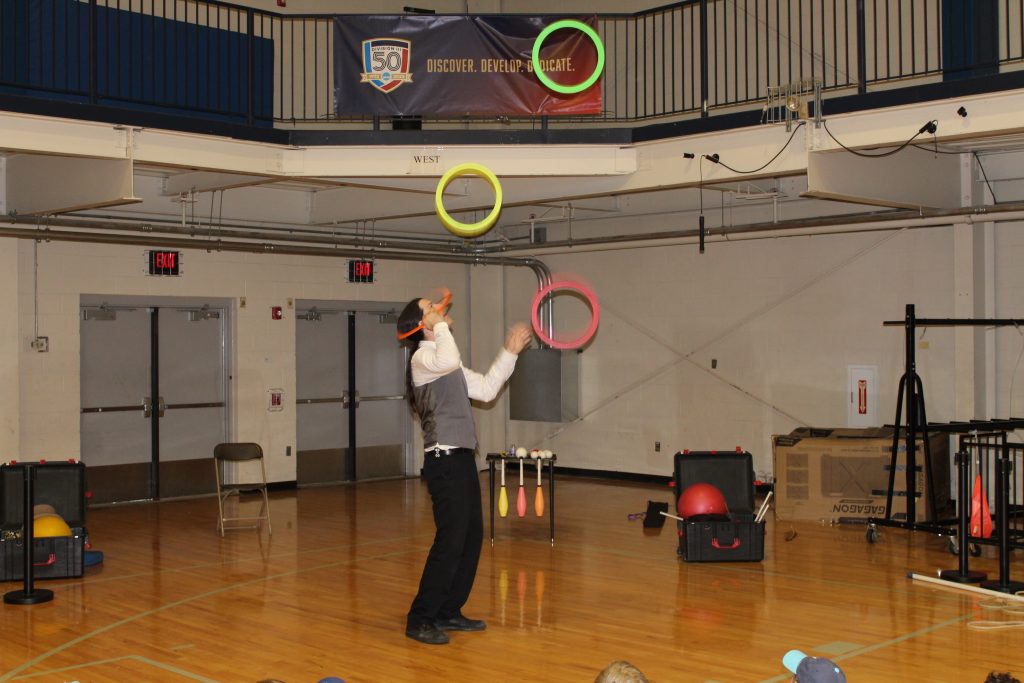 a magician throwing up colorful  hoops in the air for a special trick for the campers