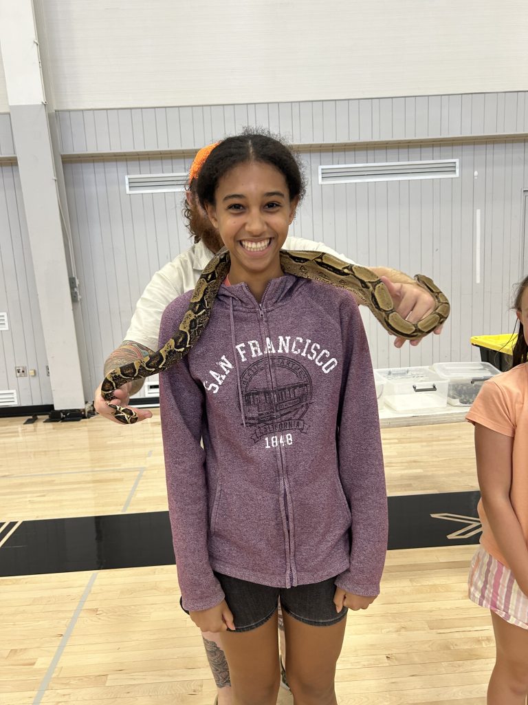 a girl wearing purple with a snake around her neck